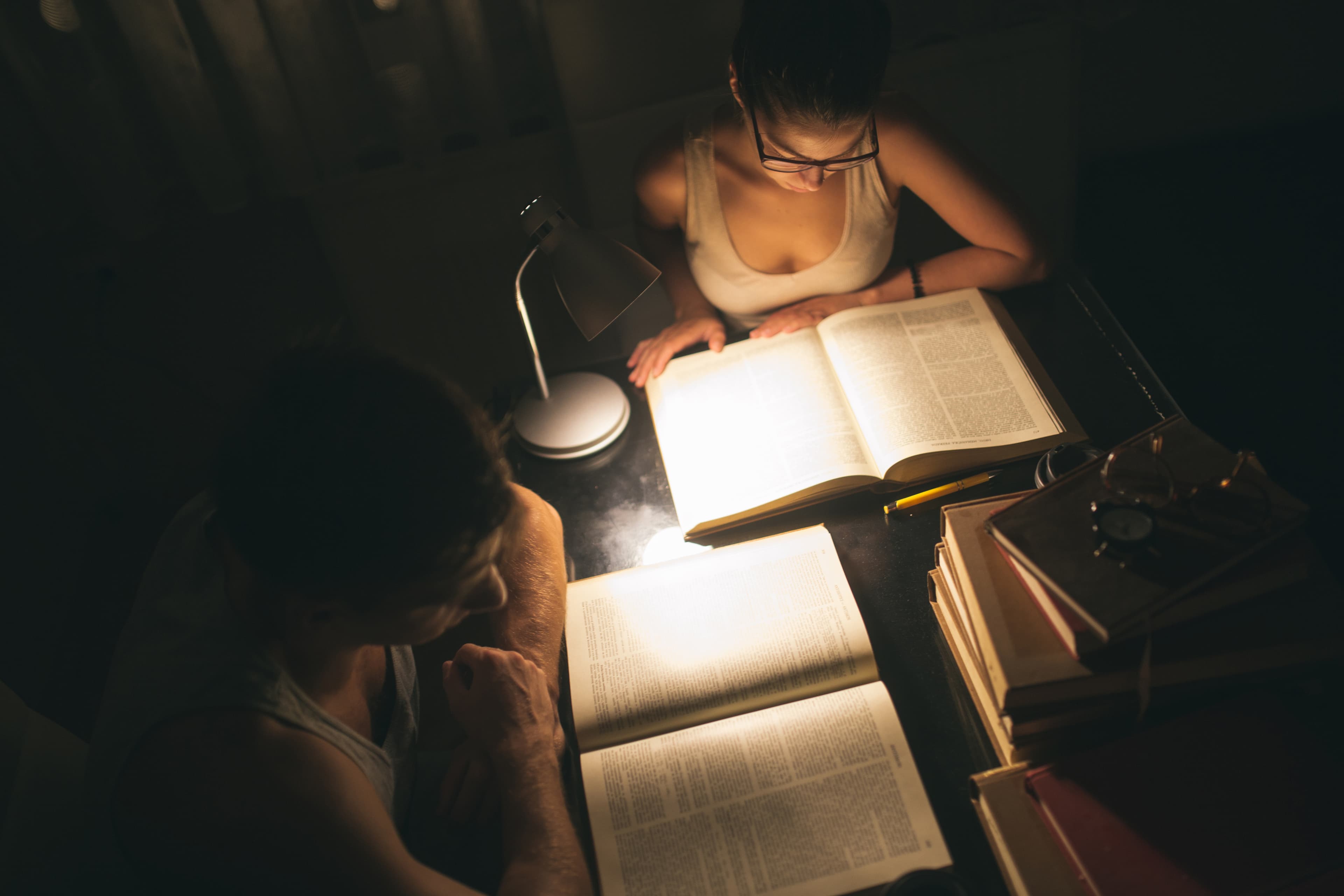 A student reading by lamplight at night